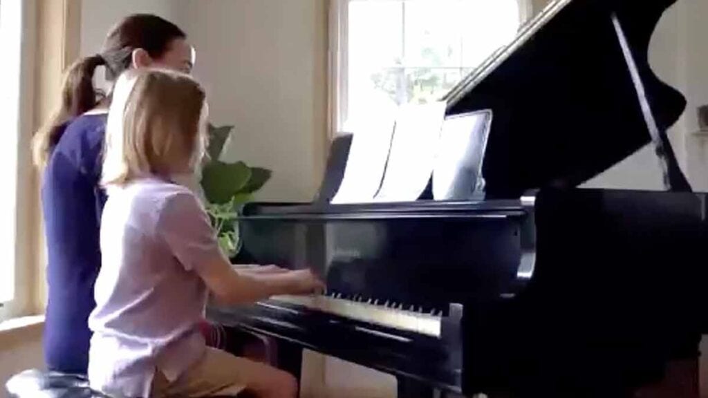 Piano Teacher and young student seated at the Piano