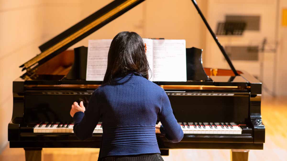 Woman playing piano at concert hall